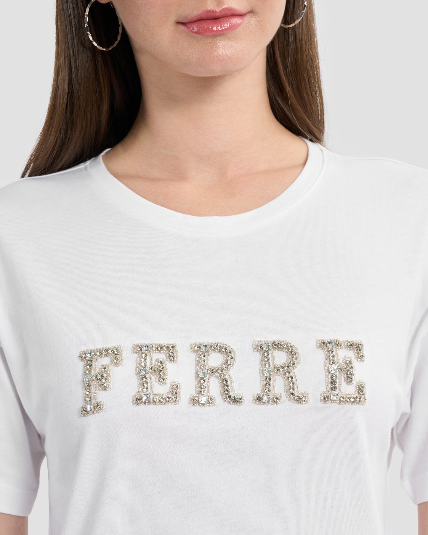 Round neck white t-shirt with rhinestones embellished Ferré branding to front.